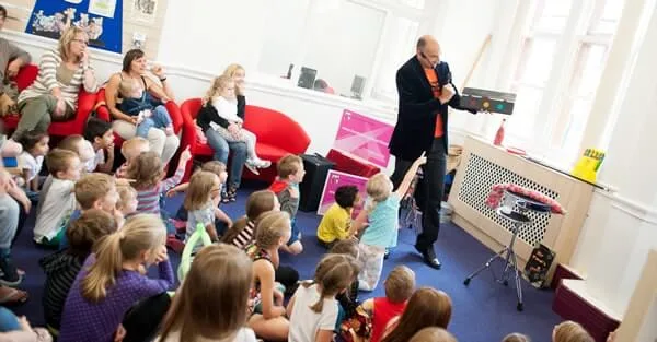 Mr Tinsel performing in front of a room full of seated children