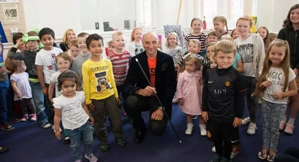Mr Tinsel standing among a group of children and adults